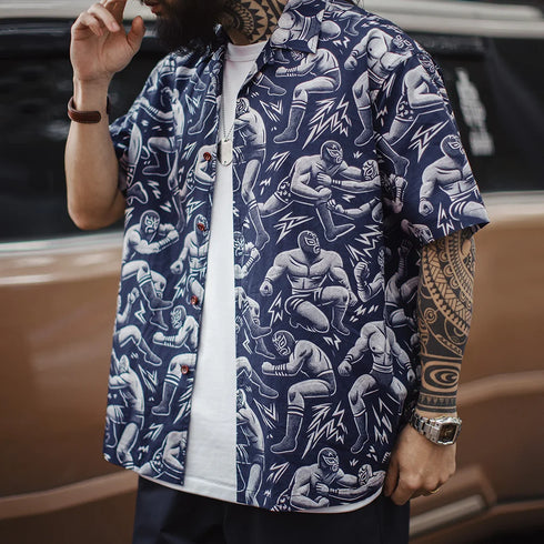 Person wearing a navy blue shirt with white graphic designs of muscular figures.